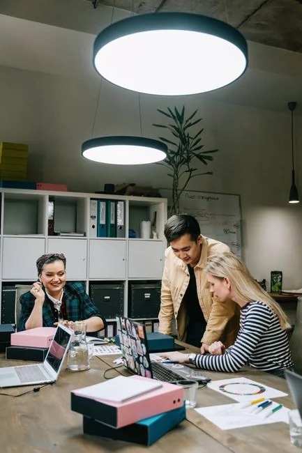 Team members discussing digital graphs on a tablet in a modern office setting.